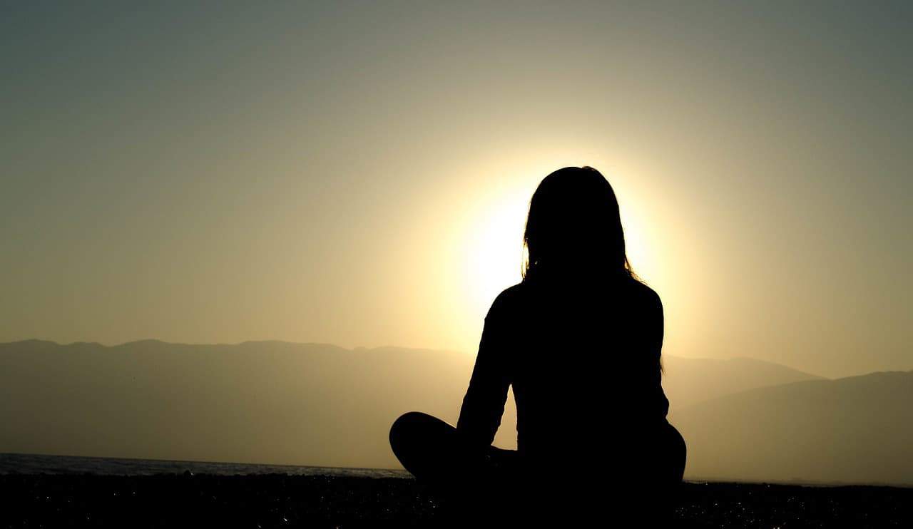 silhouette of woman meditating