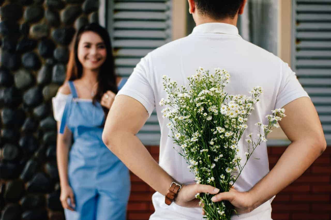 man hiding flowers