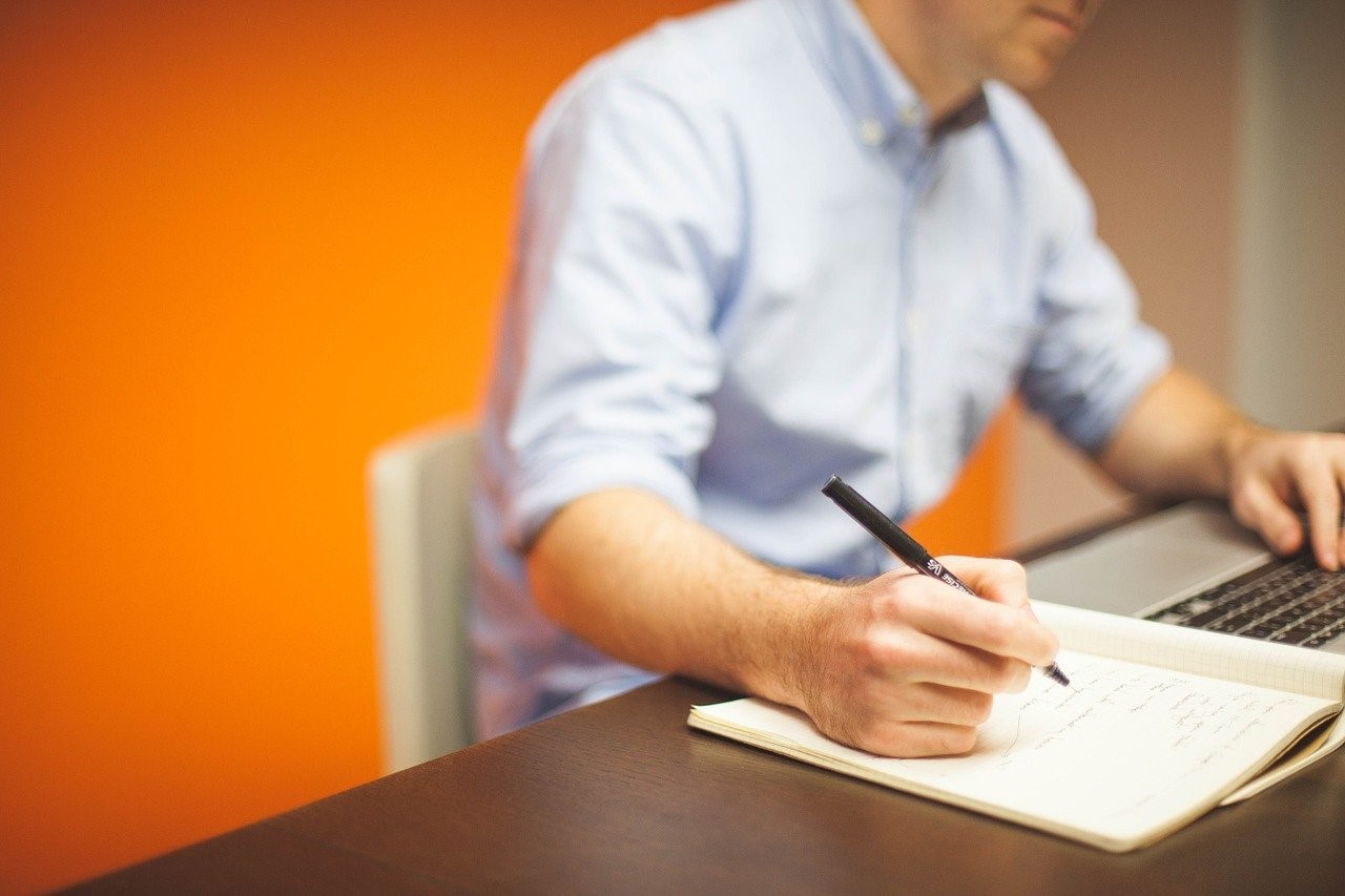 man taking notes at his desk