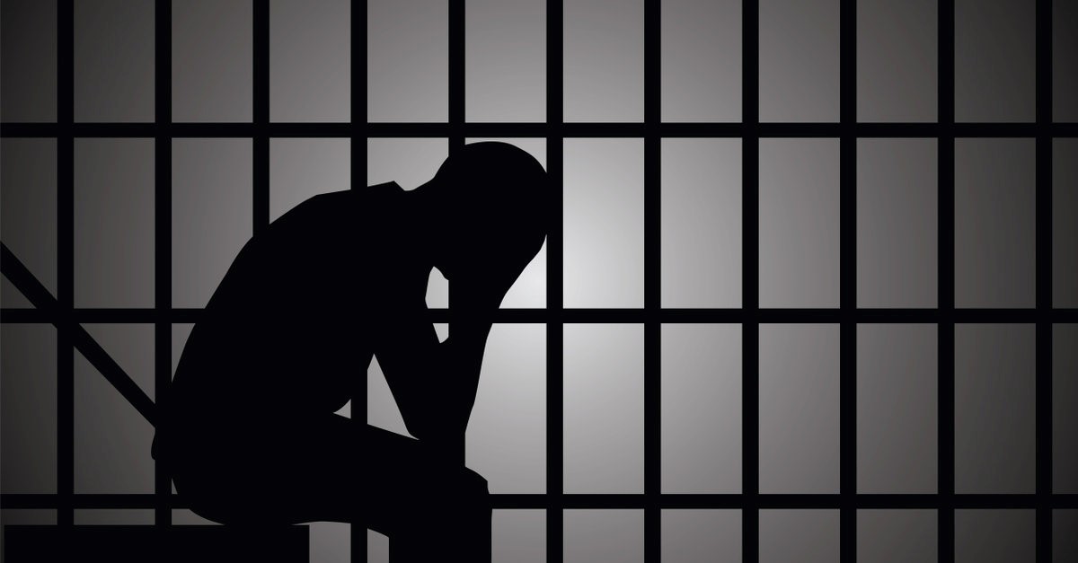 silhoutte of a man in a jail cell