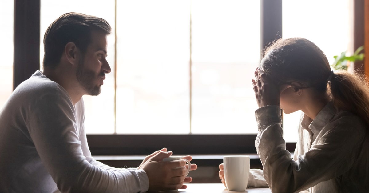 man and woman talking at a cafe