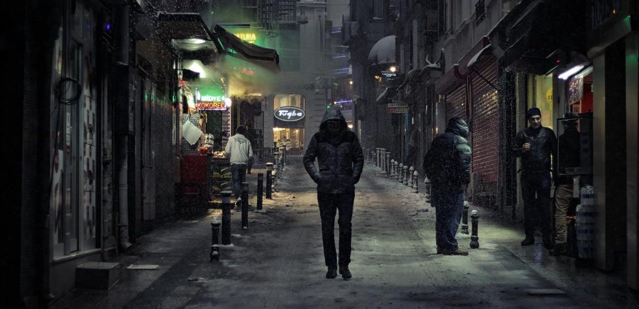 man in a hoodie walking alone at night