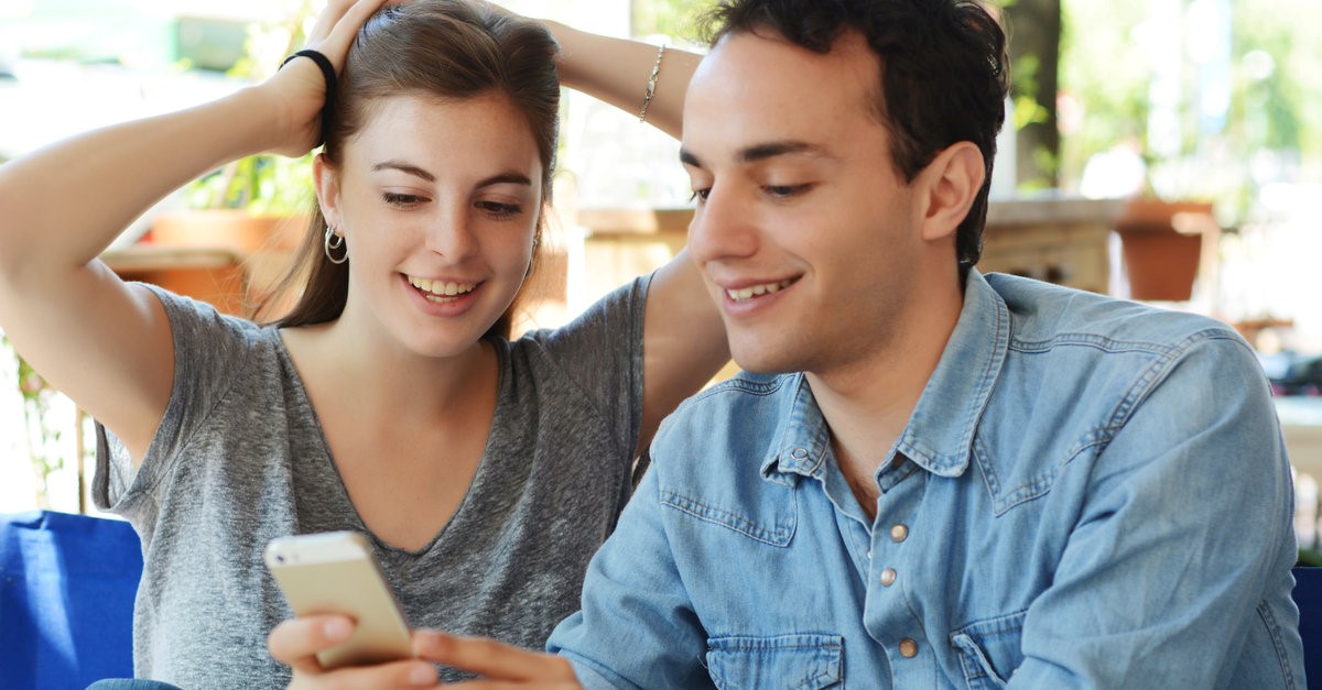 man showing off his phone to girlfriend