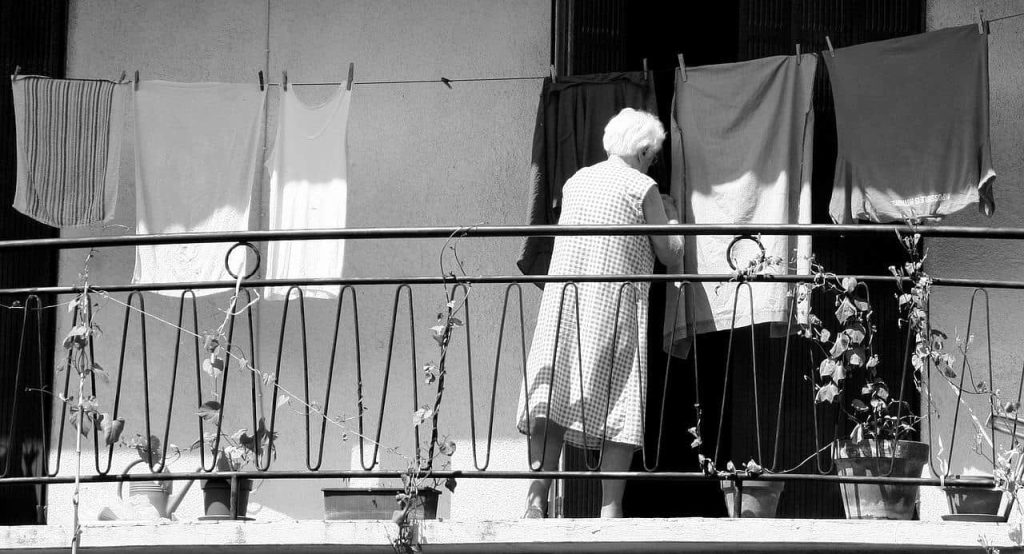 old woman hanging clothes