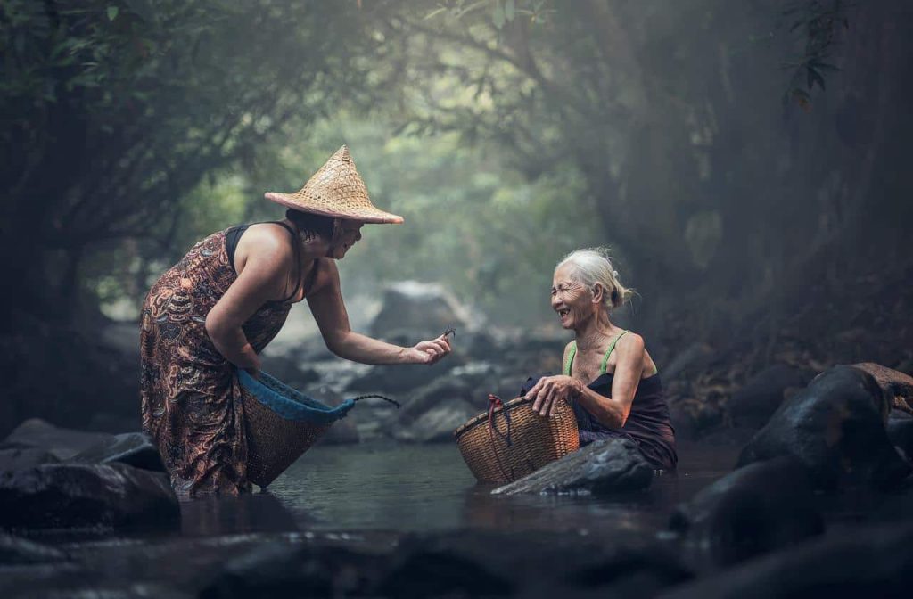 old women washing clothes in the river