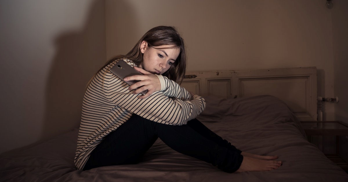 sad woman sitting on bed