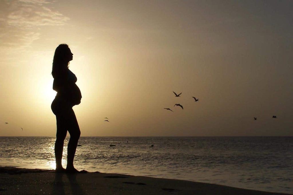 silhoutte of pregnant woman on beach