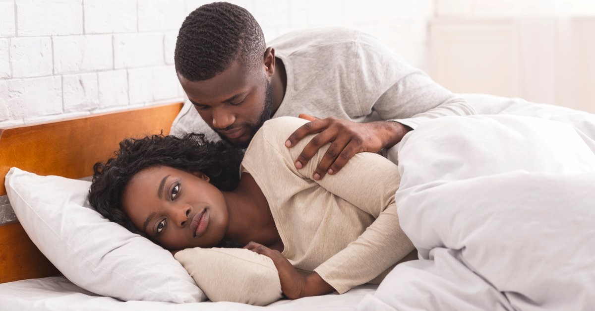 woman ignoring man in bed