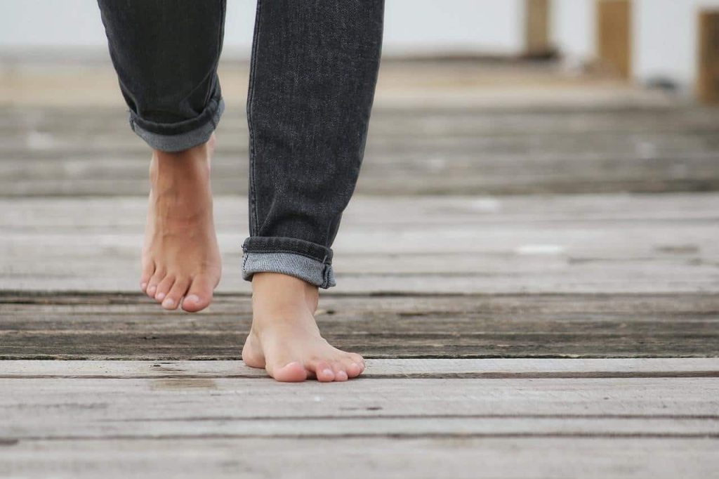 man walking barefoot on wood