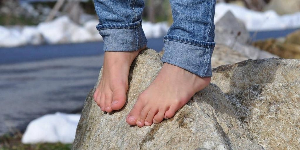 standing barefoot on a rock