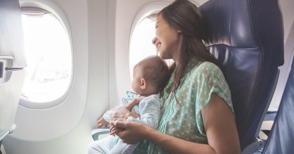 woman and baby smiling at an airplane
