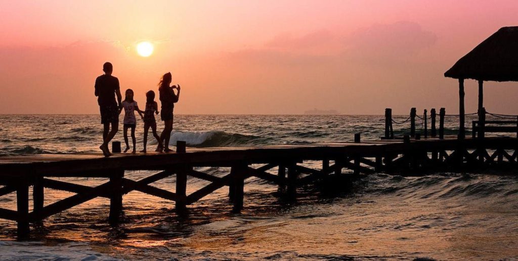 silhoutte of family standing on a dock