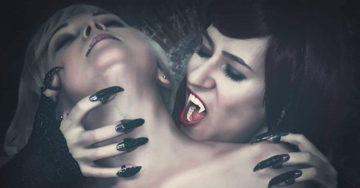 vampire with long nails about to bite a girl