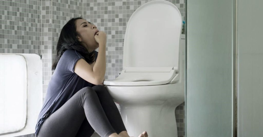 woman forcing herself to vomit