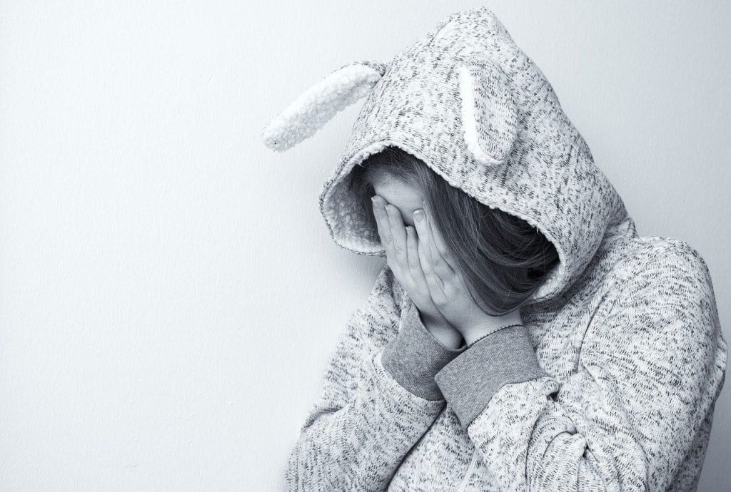 woman in bunny jacket covering her face