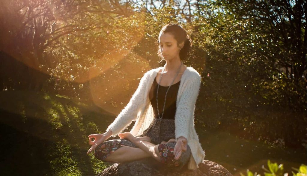 woman meditating in the forest