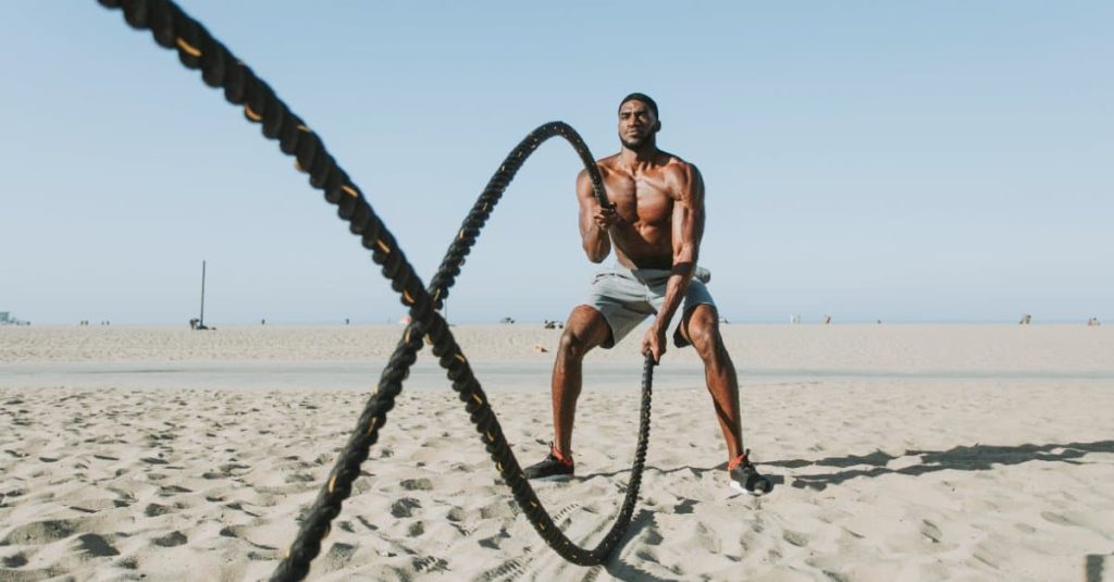 fit man with battle ropes