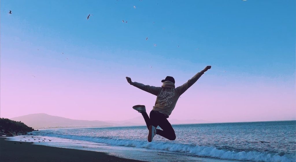 man jumping on a beach during sunset