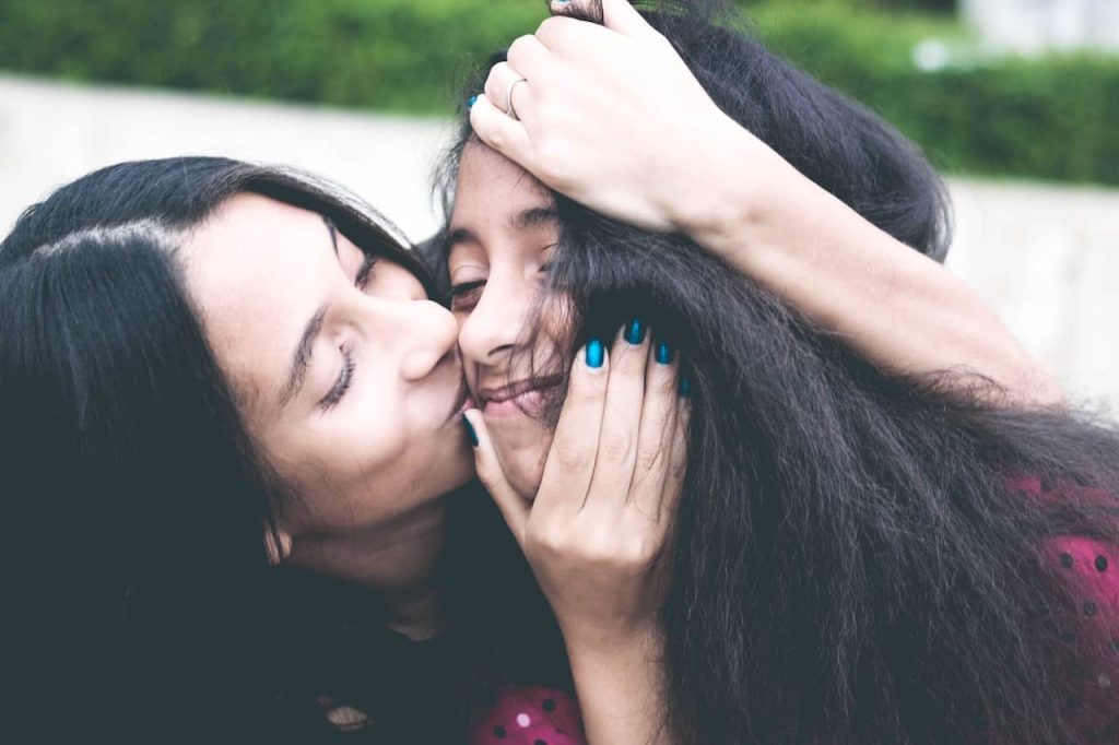 mother kissing her daughter