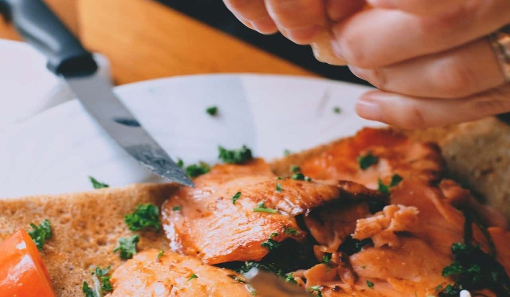 woman garnishing salmon