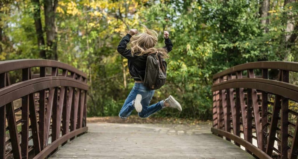 girl jumping on a bridge