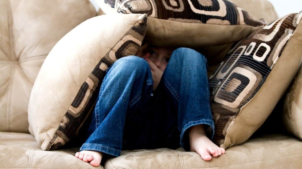 kid hiding on pillow