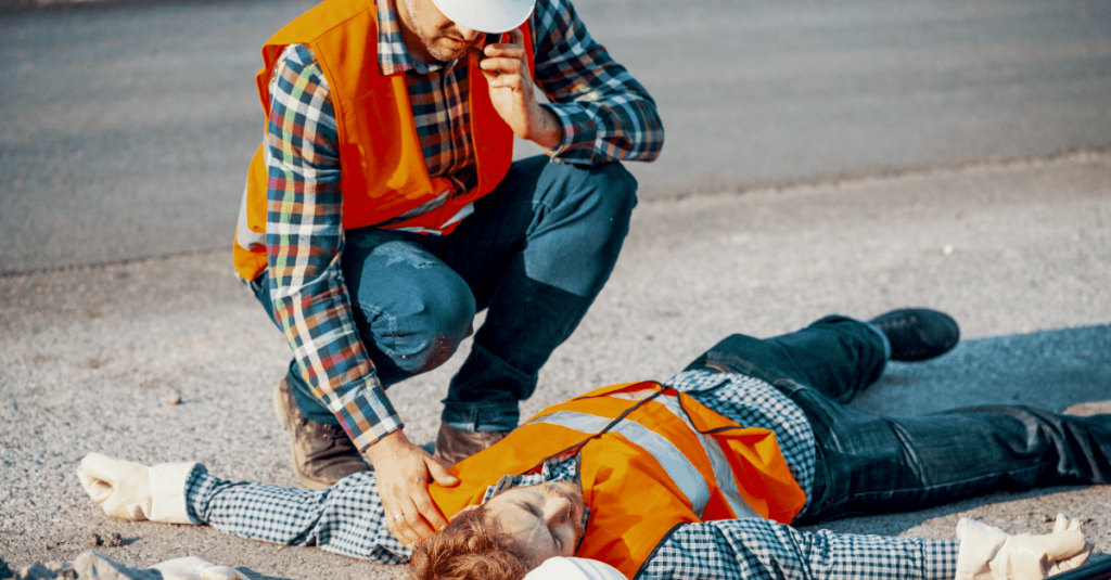 man calling ambulance for unconscious coworker