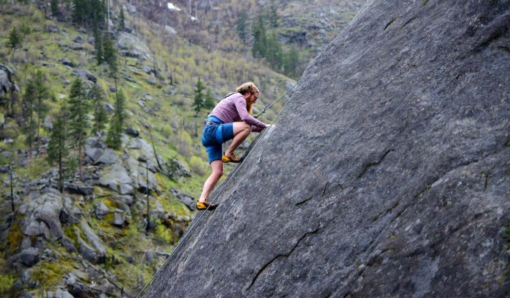 man climbing on rock mountain