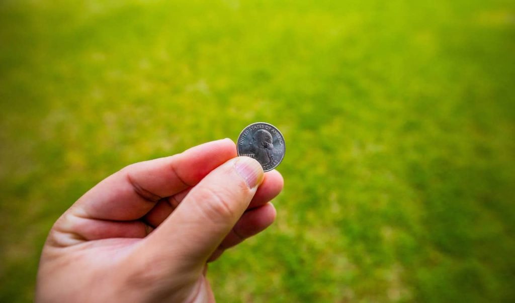 man holding silver coin