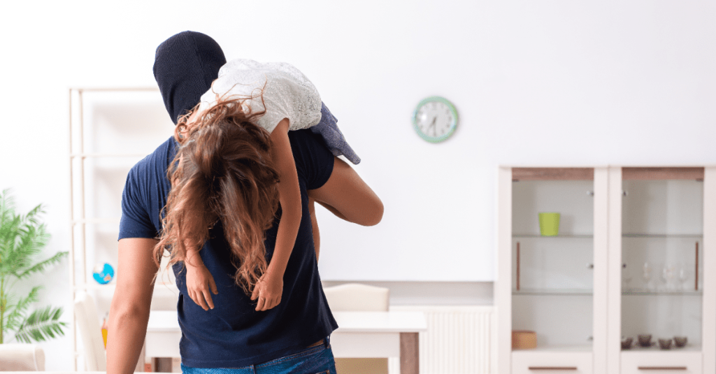 masked man carrying an unconscious girl on his shoulder