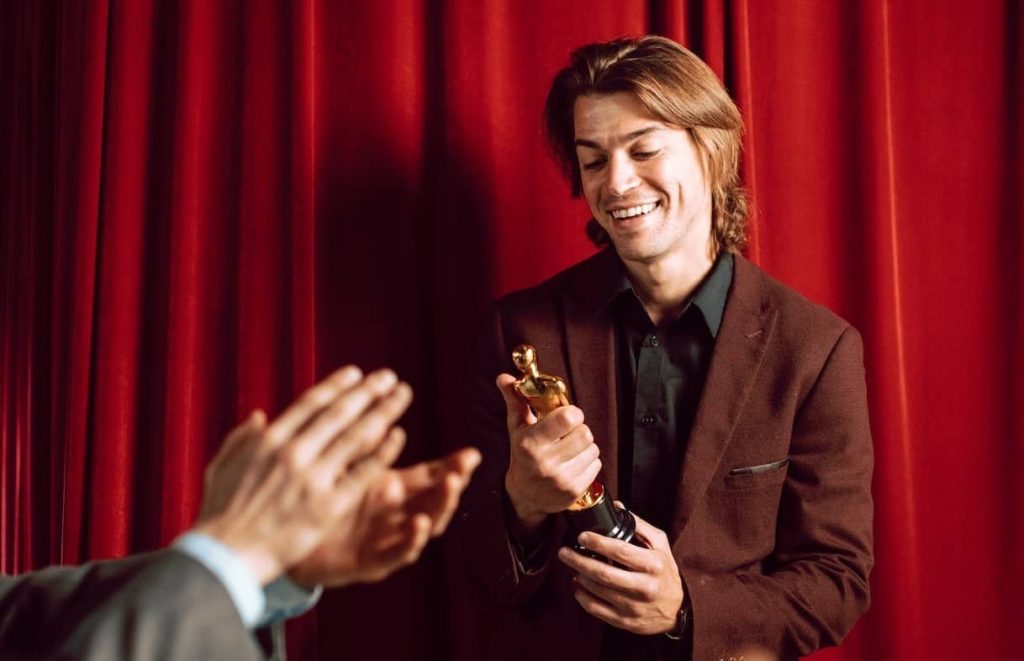 people applauding man receiving an award