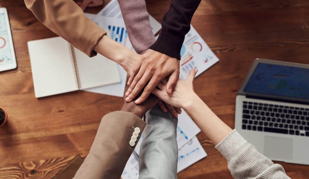 people placing their hands on top of each other