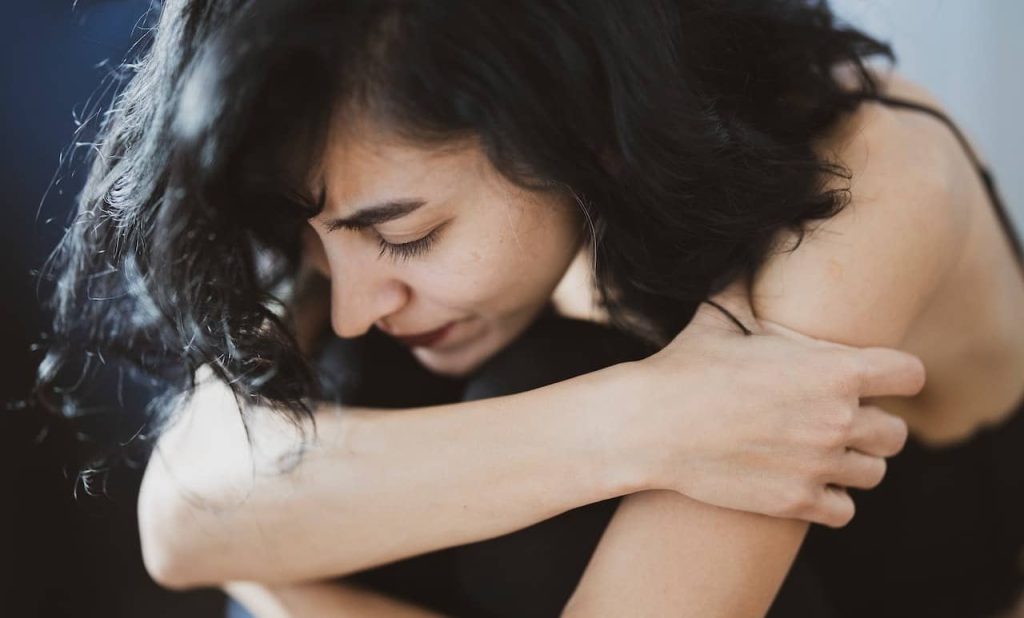 woman hugging her knees