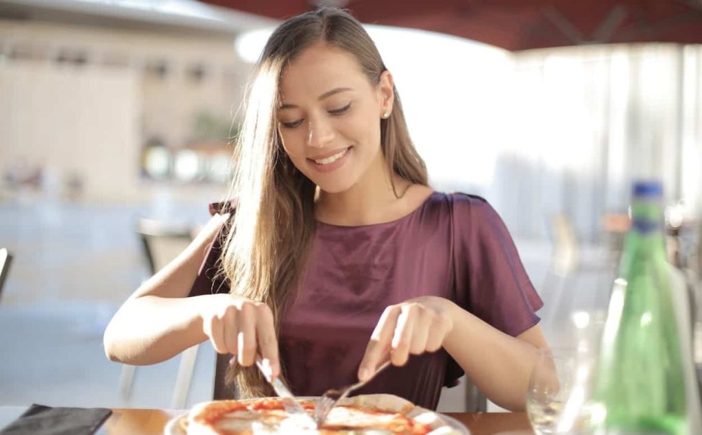 woman slicing pizza