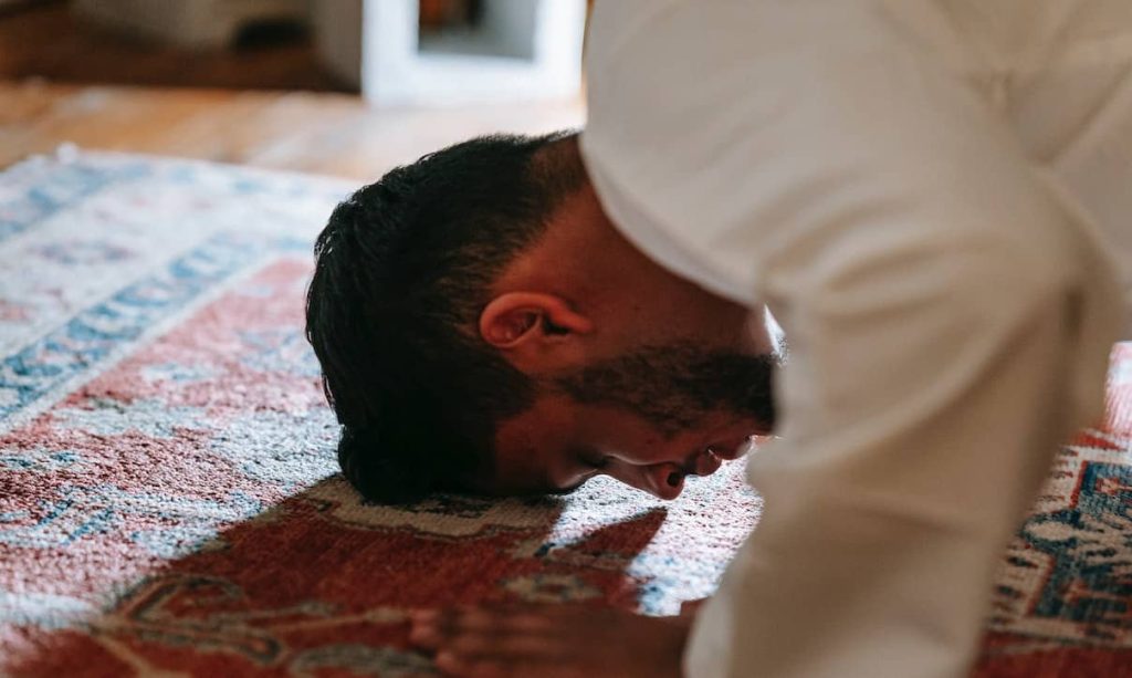 man bowing on a rug