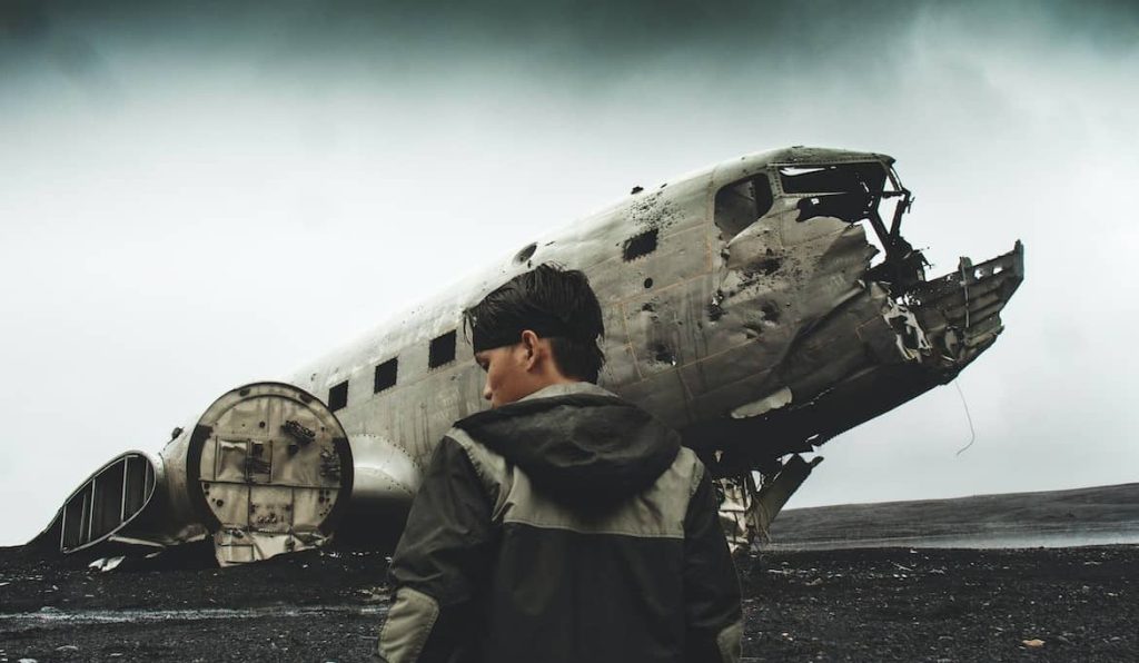 man standing near a crashed plane