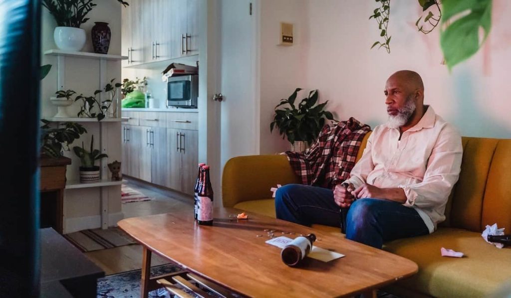 man watching tv while drinking beer