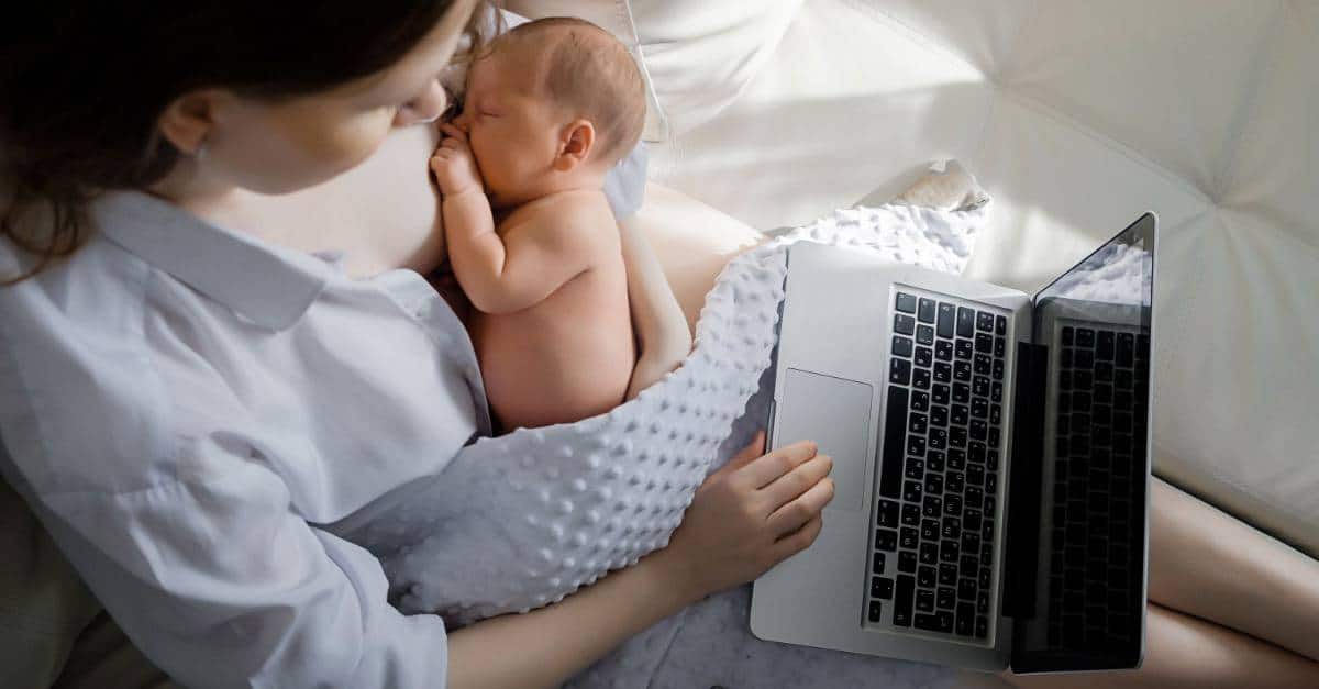 woman breastfeeding baby while working