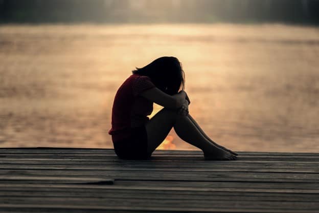 girl sitting on a wooden dock