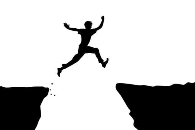 man jumping over another cliff