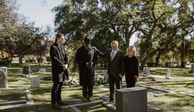 people standing over a grave