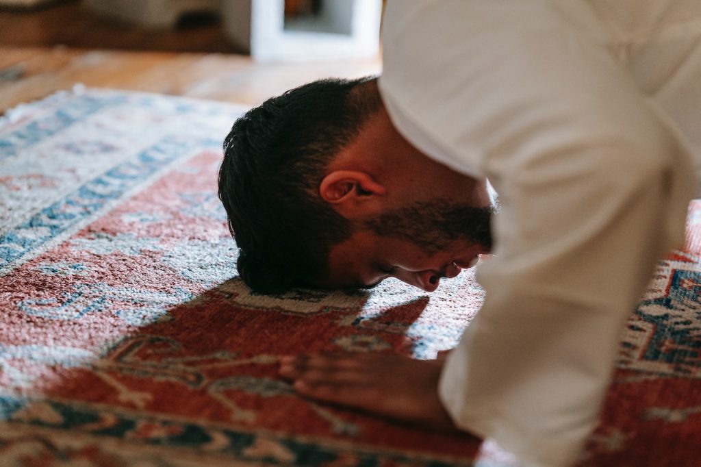 person bowing on a rug
