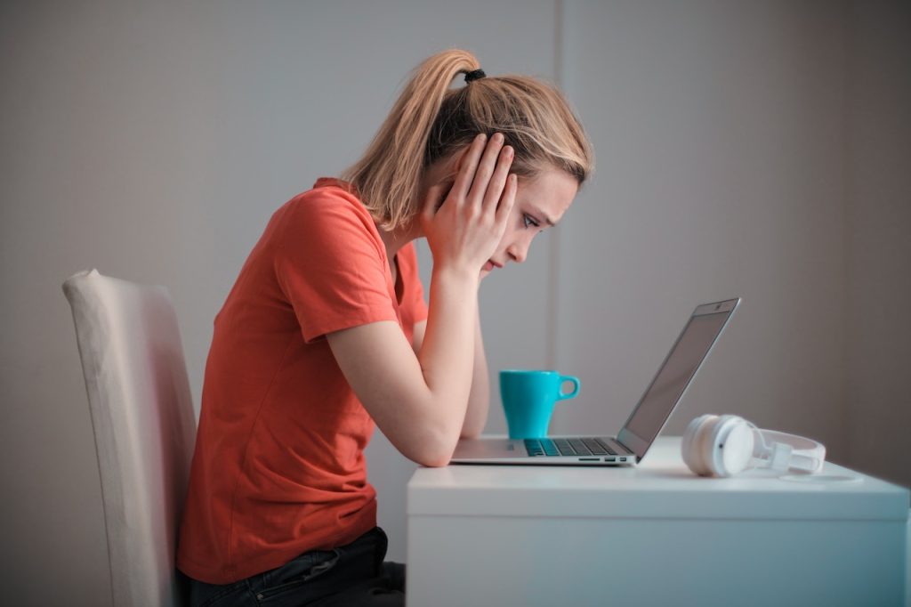 sad young woman in front of her laptop