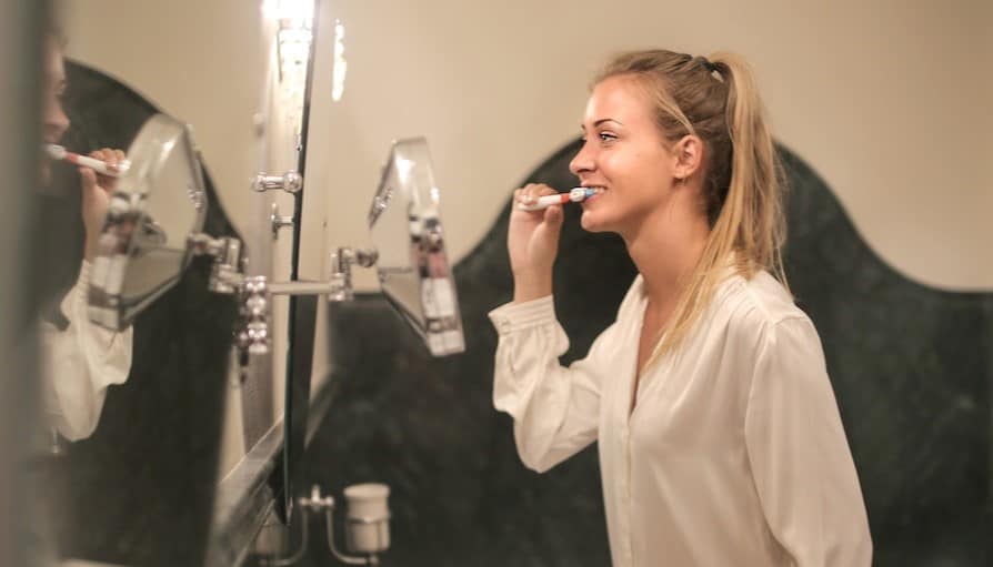 woman brushing her teeth in the bathroom