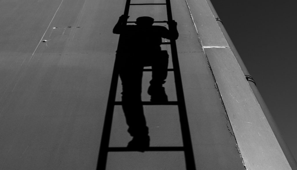 shadow of a person climbing a ladder